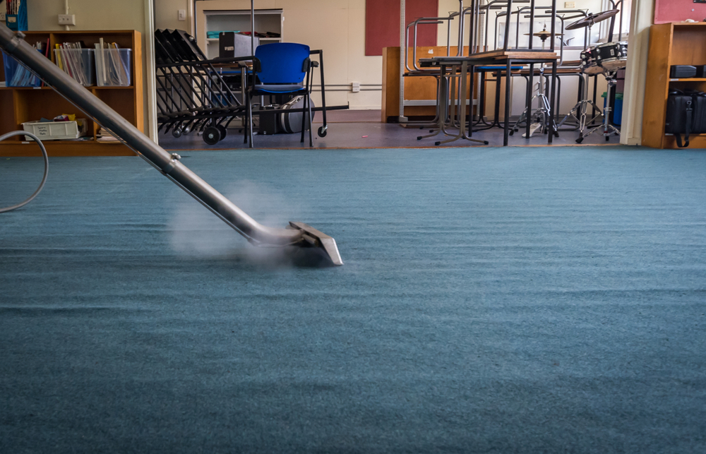 A Steamatic professional steam cleans the carpet in an office building